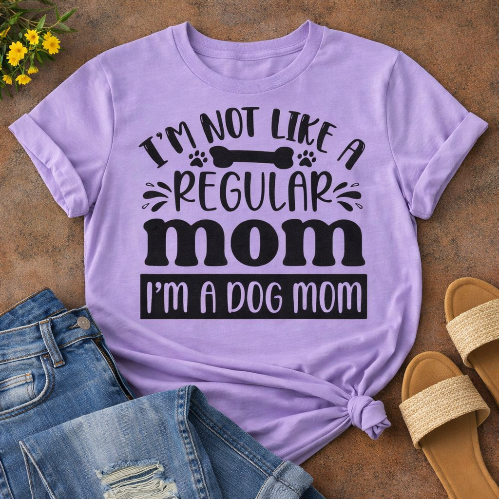 Funny dog mom quote “I’m Not Like a Regular Mom I’m a Dog Mom” SVG design on purple T-shirt mockup with jeans and sandals, Cricut dog lover shirt idea