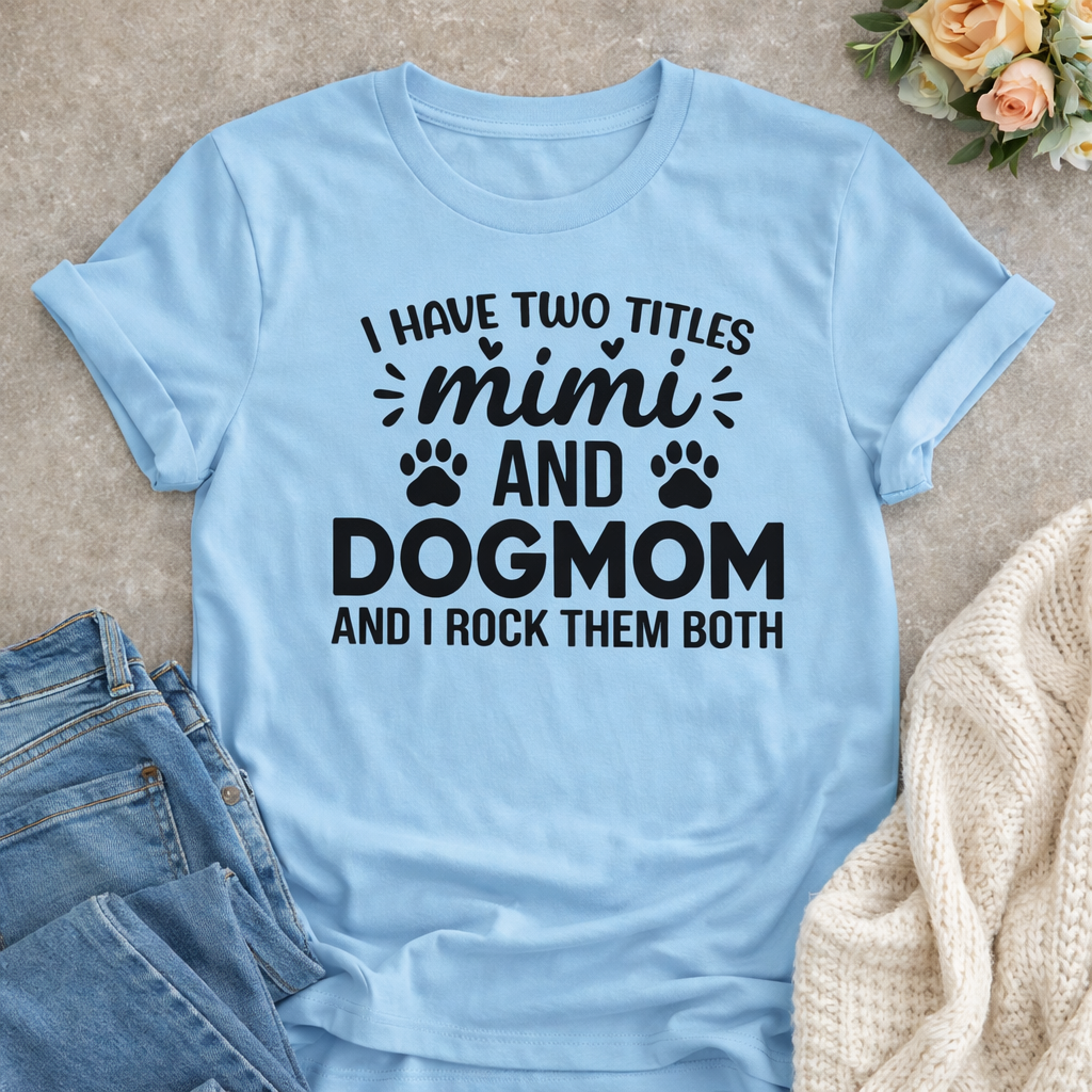 Light blue dog lover T-shirt mockup featuring the quote “I Have Two Titles Mimi and Dog Mom and I Rock Them Both” styled with jeans and cozy sweater
