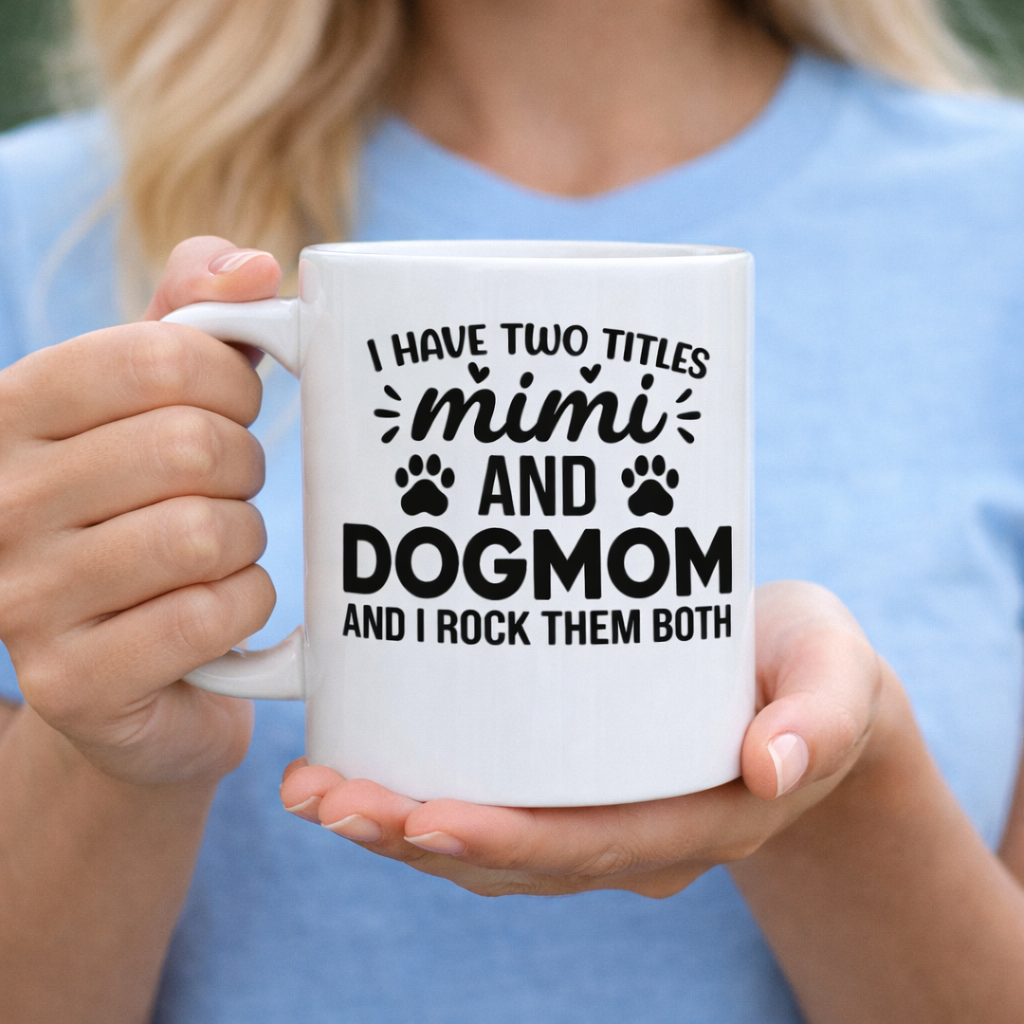 White ceramic mug with “I Have Two Titles Mimi and Dog Mom and I Rock Them Both” graphic design held in hands, dog mom themed gift idea