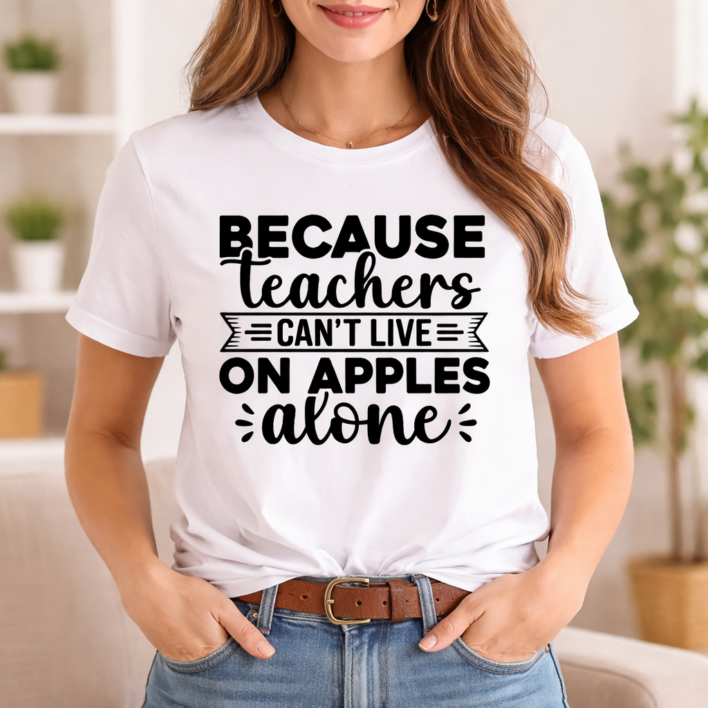 Woman wearing white T-shirt with “Because teachers can’t live on apples alone” SVG design in black, waist-up view in bright indoor setting – Funny Teacher SVG Quotes