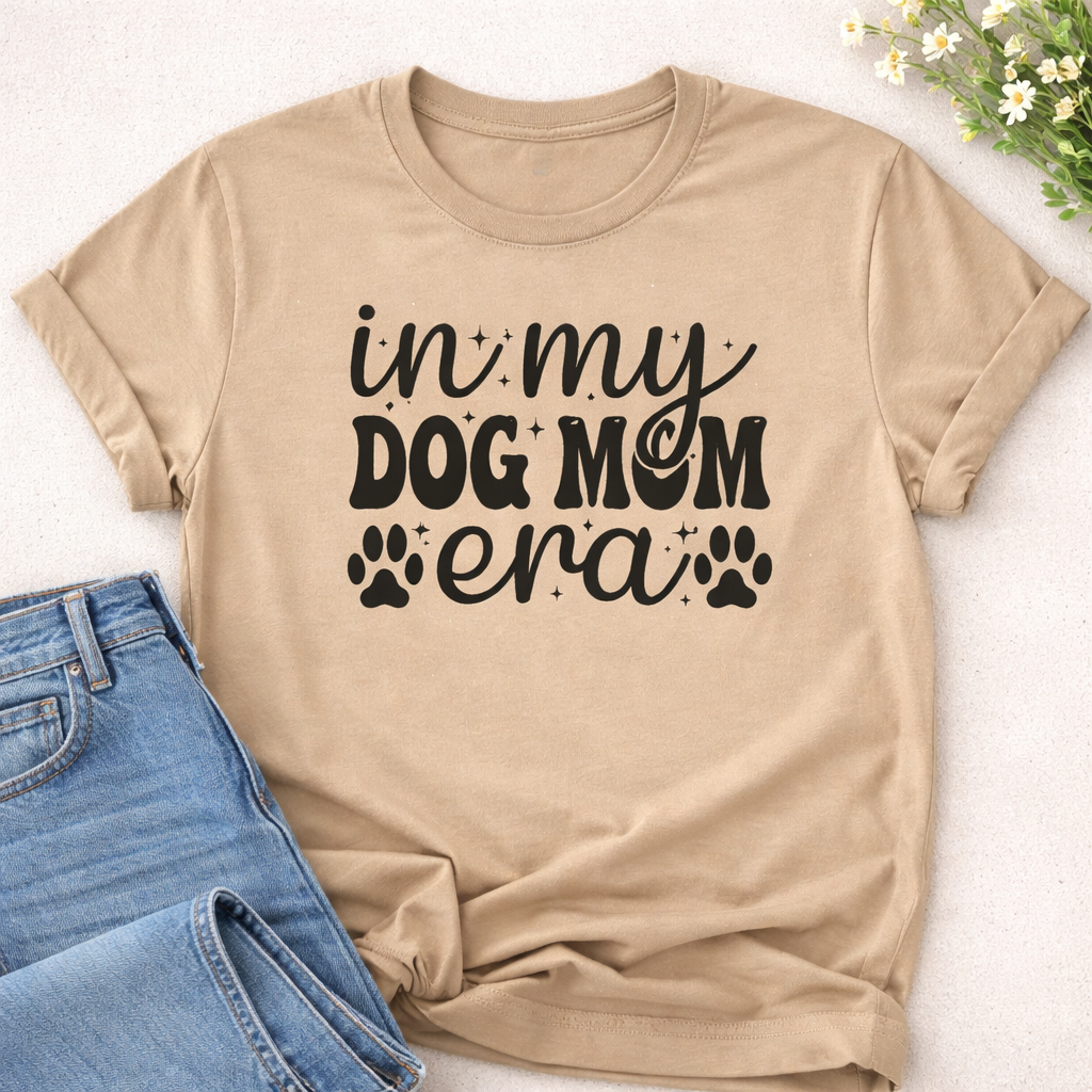 Beige T-shirt mockup with In My Dog Mom Era SVG design, dog mom quote with script lettering and paw prints, styled with jeans on neutral background