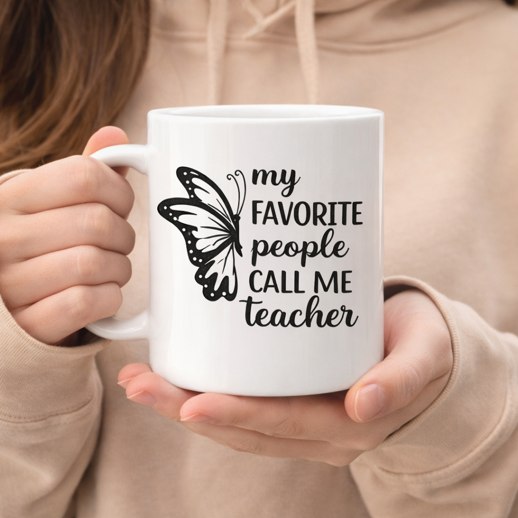 White mug with “My favorite people call me teacher” SVG design and butterfly graphic, held in hands in cozy indoor setting – Funny Teacher SVG Quotes