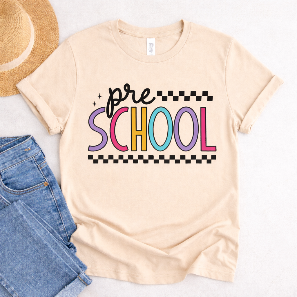 Beige t shirt flat lay featuring Preschool SVG design in colorful retro letters with jeans and straw hat styling